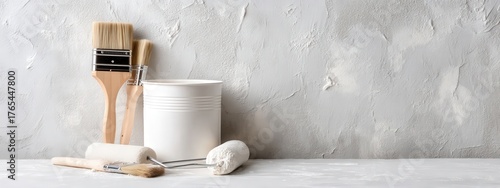 Clean and minimalist studio shot of painting tools on a textured white background