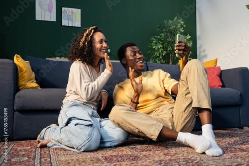 Black couple making video call smiling waving at home