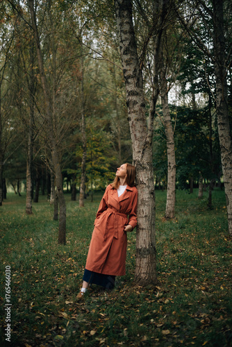 A girl in a cloak near a tree