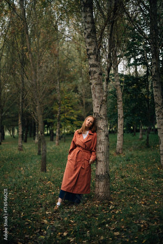 A girl in a cloak near a tree
