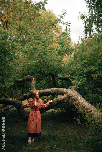 A girl in a cloak near a tree