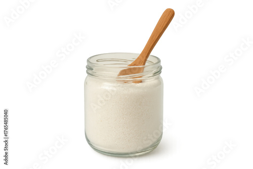 Granulated sugar in glass jar with wooden spoon