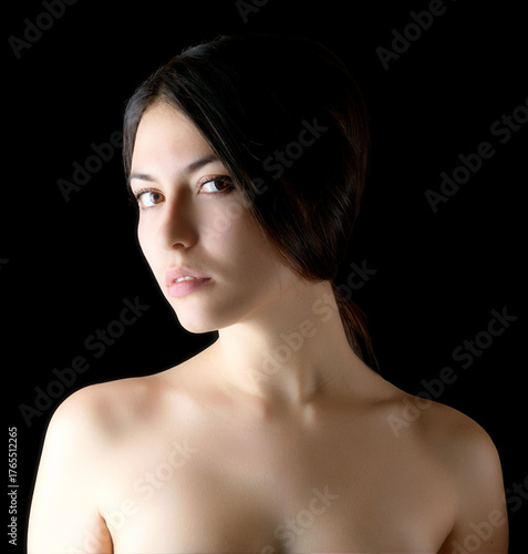 Elegant portrait of a young woman on a dark background.