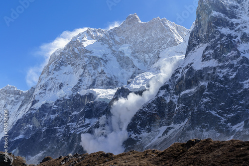 Snowfall cascades down a majestic mountain peak