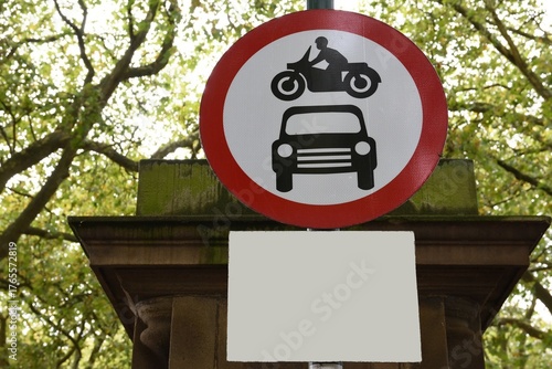 Road sign. Close up—motorcycle over a car inside a red-bordered circle. No vehicles.
Copy space for text or image.

