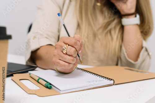 woman working in the office taking notes in a notebook