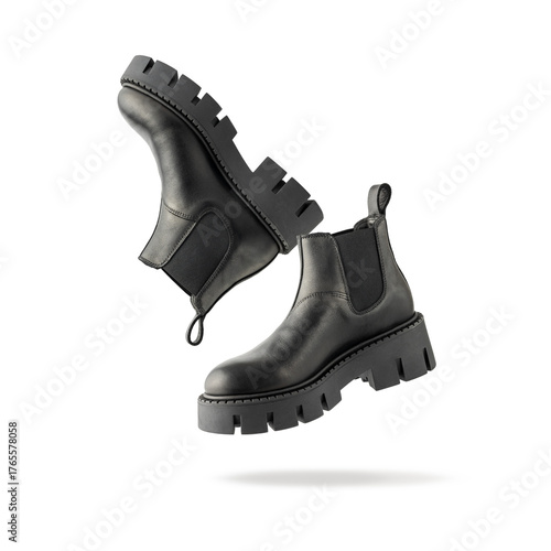 Trendy fashionable black leather short womens chelsea boots with rough sole flying isolated on white background.