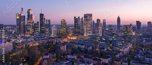 Aerial view of twinkling skyscrapers pierce the twilight sky above the illuminated streets and buildings of Frankfurt, Frankfurt am Main, Hessen, Germany.