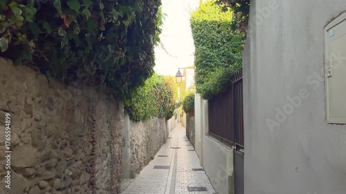 A Narrow street in famous summer town called Saint-Tropez located in French riviera. Old, traditional buildings are in the view.