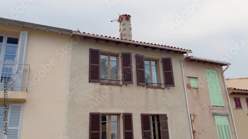 Bottom view of old, traditional buildings in famous summer village called Antibes in French riviera. It shows french architectural style.