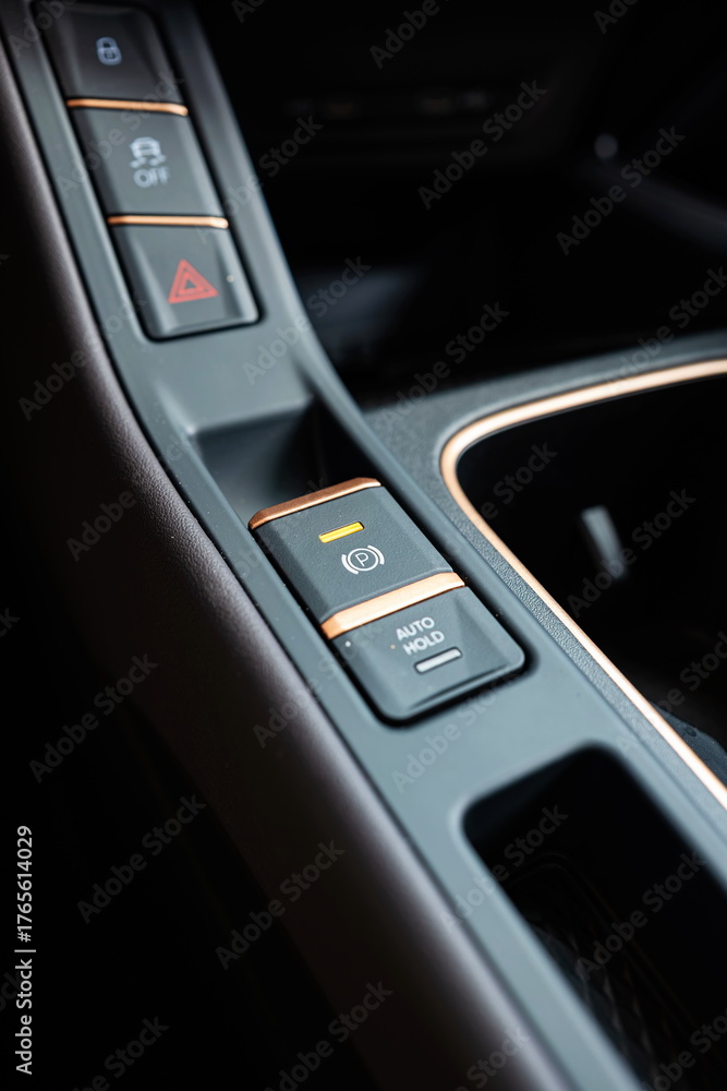 Naklejka premium New car electric push pull handbrake button on the dashboard. Close up detail shot, no people