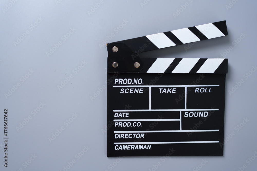 Fototapeta premium Black and white movie clapperboard on gray background, concept for filmmaking, video production, movie industry, creativity, media content, and cinematic storytelling.