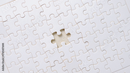 White puzzle with one missing piece on light background, symbolizing problem solving, teamwork, incomplete task, solution finding, and strategic thinking concept.