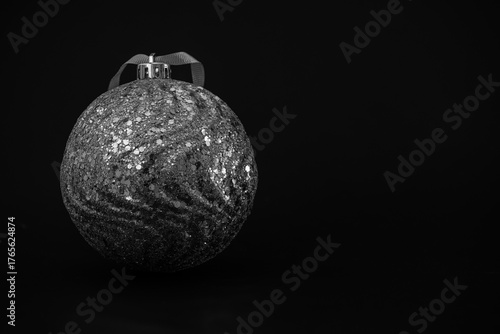 Silver Christmas bauble on a black background.