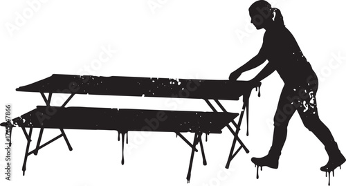 Silhouette of a woman setting up folding tables for an outdoor e