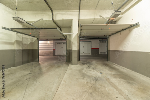 Garage with a stone-clad facade to match the house, an insulated steel door, and a surveillance window.