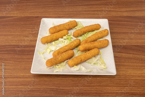 Crispy chicken strips breaded with precooked corn flour and Venezuelan spices, accompanied by creamy guacamole and slices