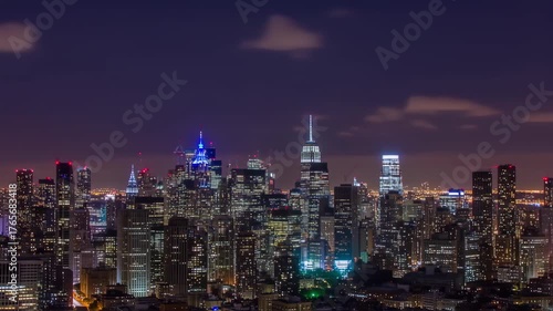 New York City Skyline at Night Illuminated Buildings and Clouds.