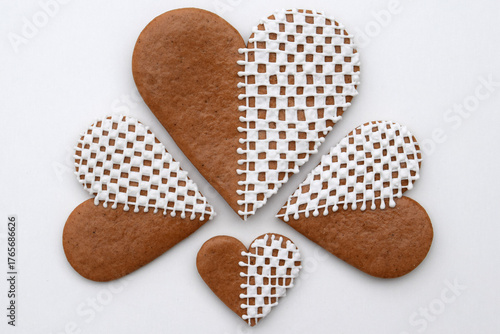 Decorated heart-shaped gingerbread cookies in three sizes on a white background