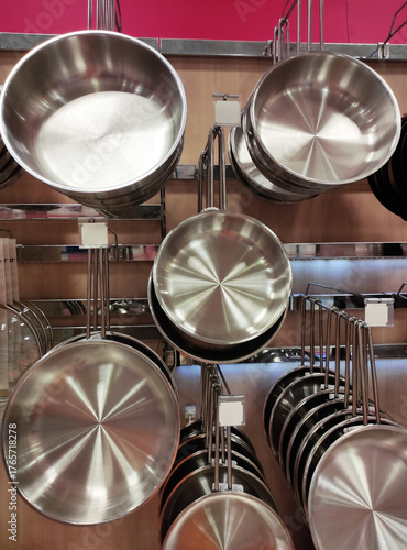 Shiny round metal steel cooking pots in the shop window
