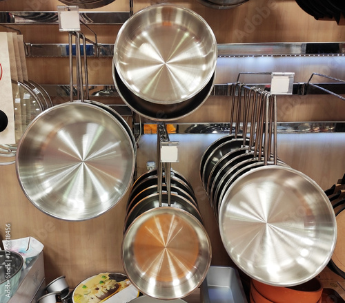 Shiny round metal steel cooking pots in the shop window