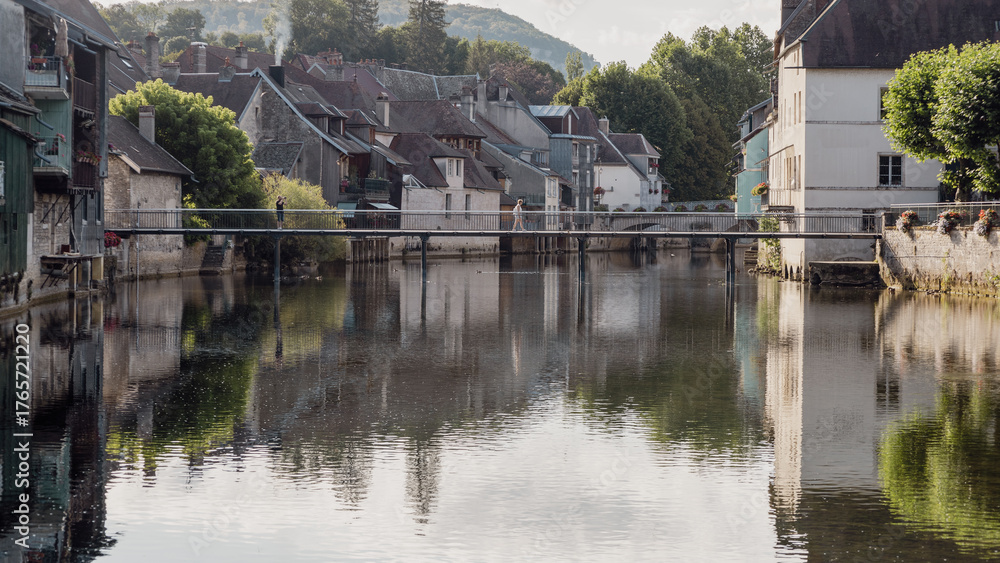 Obraz premium Au cœur de la vallée de la rivière la Loue dans le département du Doubs en France , la ville d' Ornans est un petit joyau aux maisons pittoresques suspendues au-dessus de la rivière