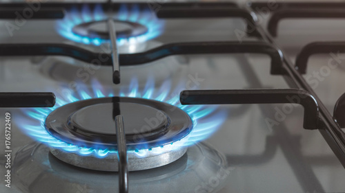 Close-up of a blue fire from a kitchen stove. 4 gas burners with a burning flame. economy concept.