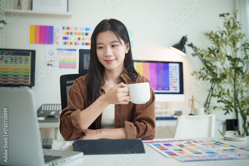 Creative professional taking a short break with coffee while working on design project at modern office.