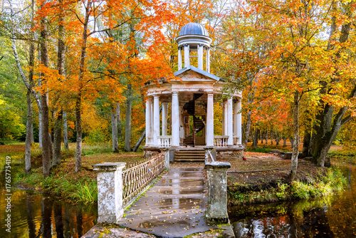 Late autumn in old public park, walking bridge and abandoned ancient resting ...