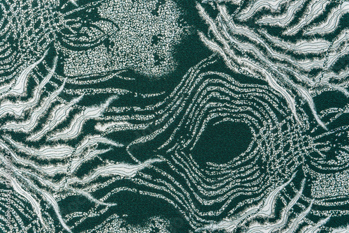 Dark teal jacquard fabric texture with metallic lurex and abstract wave pattern, part of textile collection