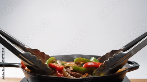 Sizzling Fajitas Being Tossed in a Skillet with Colorful Peppers and Onions in a Bright Kitchen