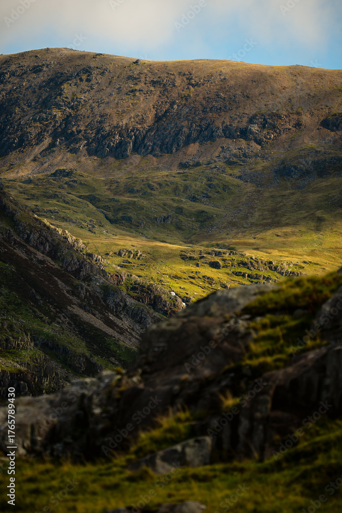 Fototapeta premium Rocky hillside and distant mountain slopes in Snowdonia, Wales