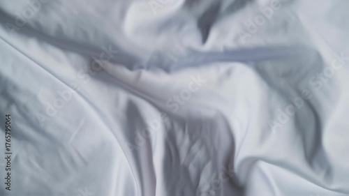 Close up of wrinkled white fabric with soft folds and textures.