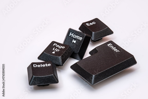 Scattered keyboard keys. “Enter,” “Delete,” “Esc,” “Home,” and “Page Up” placed on a white surface. Symbolizing computing, navigation, control and modern digital communication technology.