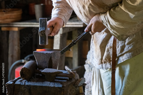 Schmied schmiedet glühendes Metall mit Hammer
