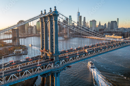 Aerial view of the majestic Manhattan Bridge, its steel cables gleaming under a soft sky, connecting to the distant skyscrapers of the city, Manhattan, New York, United States.