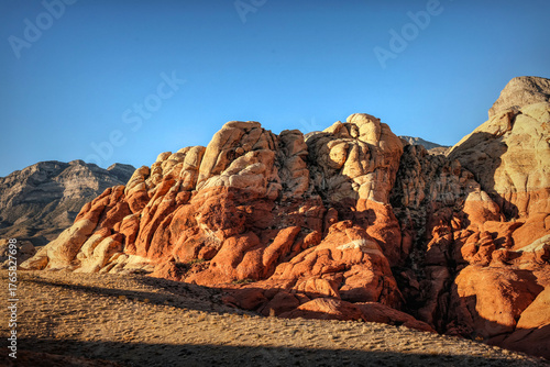 Vibrant Red Sandstone Peaks Rise Majestically Against Azure Skies in Red Rock Canyon's Ancient Desert Embrace, Nevada