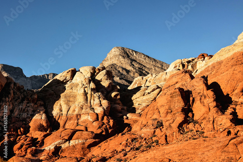 Vibrant Red Sandstone Peaks Rise Majestically Against Azure Skies in Red Rock Canyon's Ancient Desert Embrace, Nevada