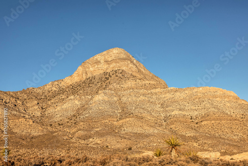 Vibrant Red Sandstone Peaks Rise Majestically Against Azure Skies in Red Rock Canyon's Ancient Desert Embrace, Nevada