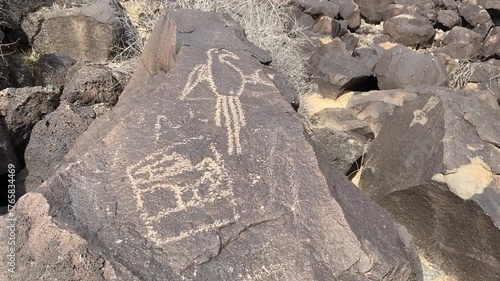 Petroglyph National Monument along West Mesa, in Albuquerque, New Mexico. Petroglyph images carved by Ancestral Pueblo people. Macaw at Boca Negra Canyon. Volcanic basalt escarpment