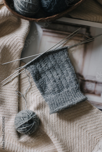 Close up of hand knitting with needles and yarn ball. Concept for handmade and hygge slow life.