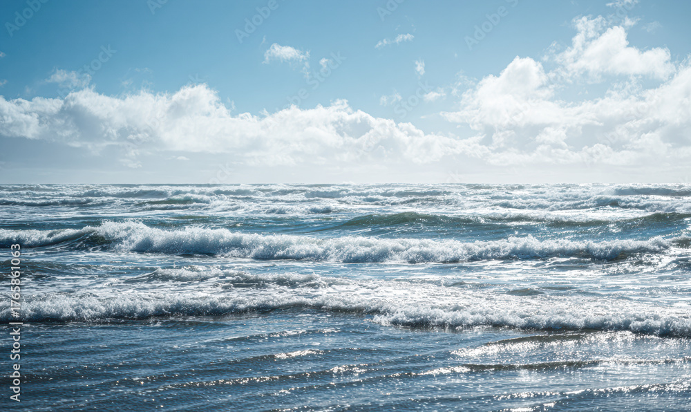 Fototapeta premium A tranquil ocean scene under a bright blue sky, with gentle waves lapping at the shore, creating a serene and peaceful atmosphere.