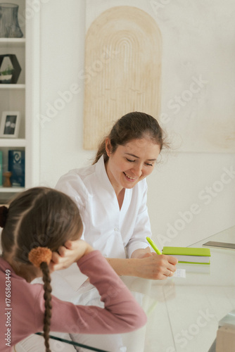 Teenage girl is listening to doctor during medical examination in modern clinic. Concept of medicine and healthcare. Part of a series. Close up