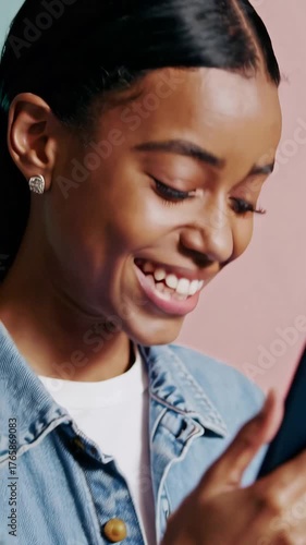 A beautiful woman smiles broadly while holding her phone, capturing a moment to share with others