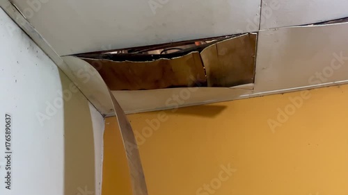 Ceiling damage visible in the corners of the room, revealing rotting wood or plaster peeling from the structure. Home problems include water infiltration and poor maintenance.
