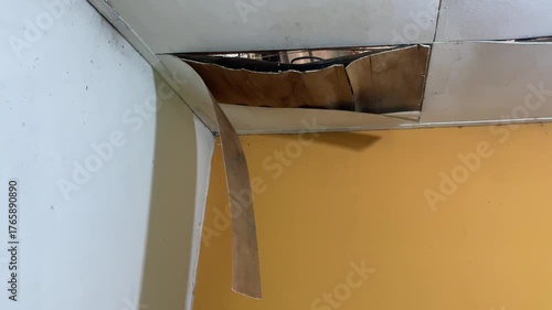 Ceiling damage visible in the corners of the room, revealing rotting wood or plaster peeling from the structure. Home problems include water infiltration and poor maintenance.