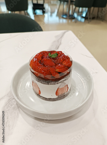 Portion of cream sponge cake with chocolate and strawberries on the background of the table. 