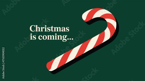 Diagonal red and white candy cane with shadow on dark green background and “Christmas is coming…” festive text for seasonal celebration