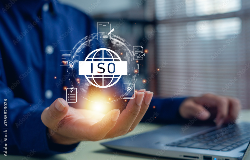 Naklejka premium Businessman holding glowing ISO certification icon with document and checklist graphics, symbolizing quality management, standardization, compliance, and corporate assurance.