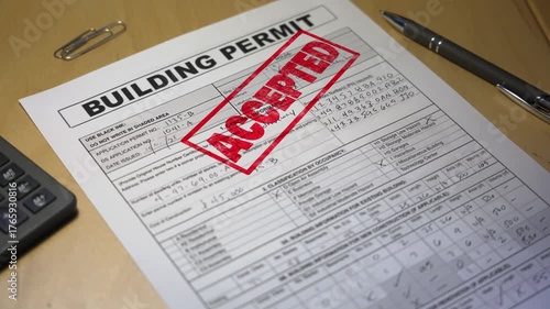 Close-up of an approved building permit stamped in red ink on a desk with a pen and calculator, symbolizing project approval and construction success. Fictional data. 14917  	